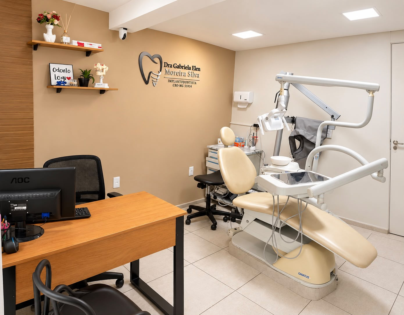 Consultório odontológico da Clínica Spazio, com cadeira de atendimento estofada em tom creme, mesa de trabalho e identificação profissional na parede